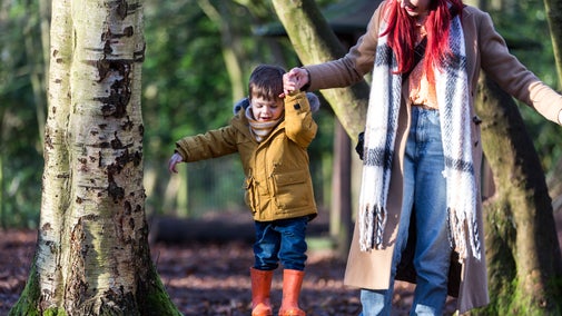 Family playing in the woodland play area at Speke Hall, Liverpool